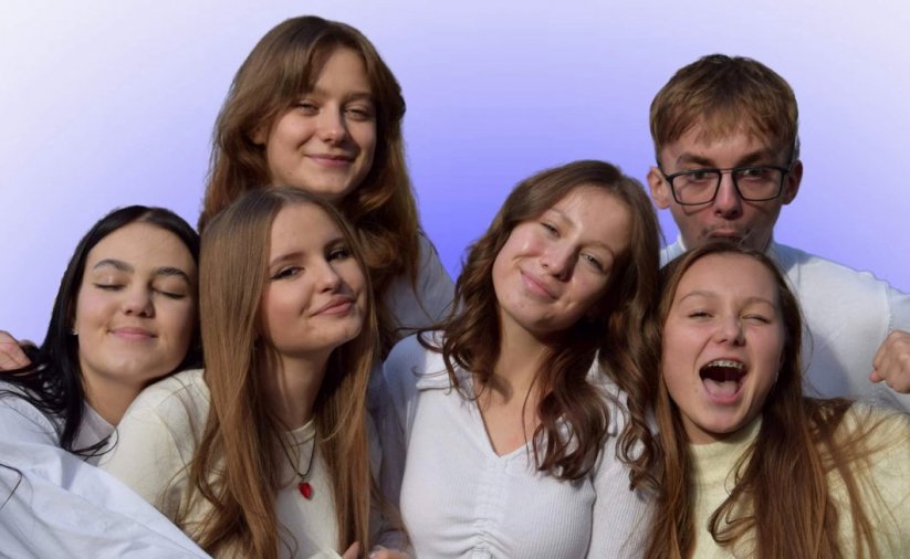 Piątka młodych usmiechniętych ludzi w białych koszulkach