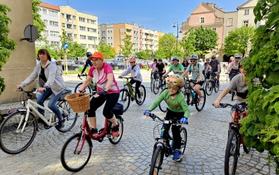 Grupa rowerzystów wyjeżdzająca z rynku