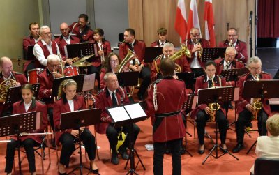 Orkiestra w jedakowych bordowych strojach podczas występu