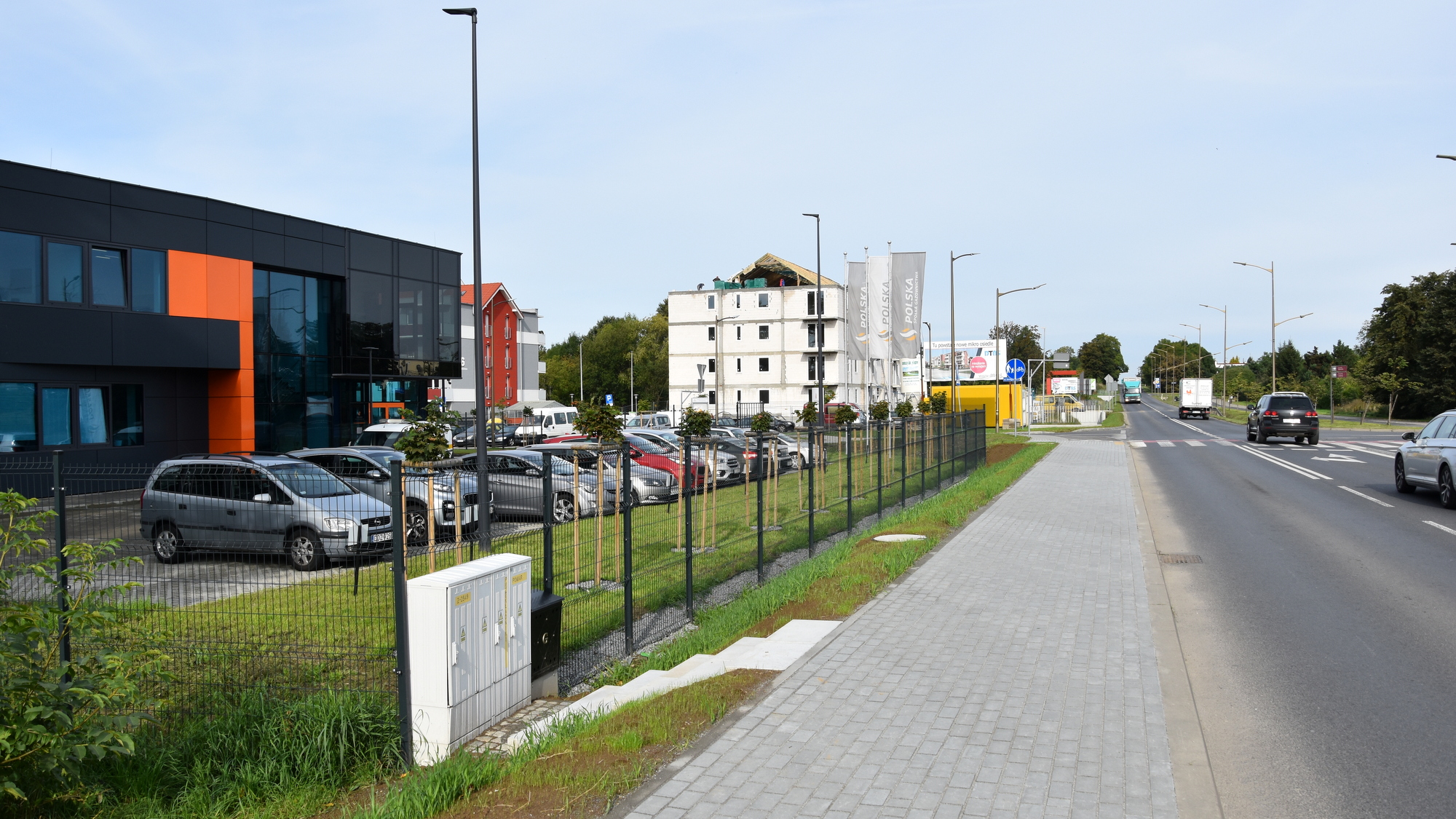 Chodnik z kostli, po lewej budynki i zieleń