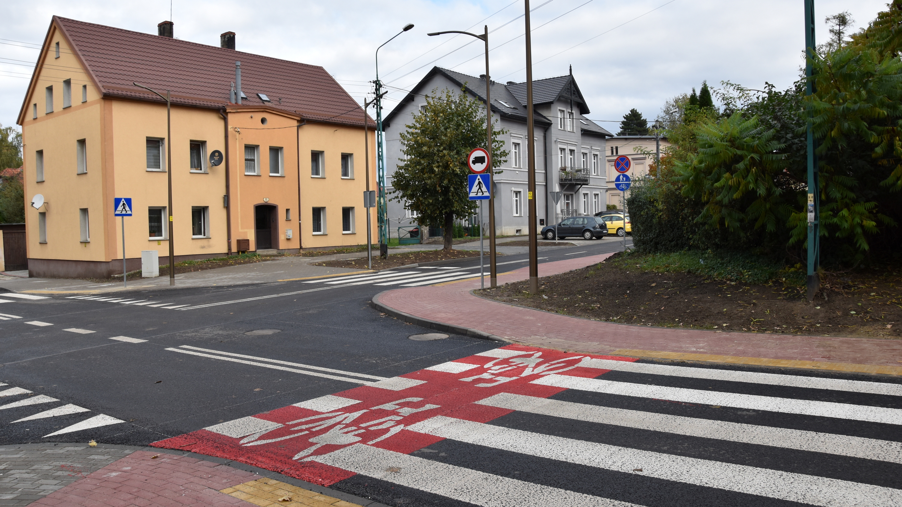 Szkrzyżoanie dróg, przejście dla pieszych i budynek z piaskową elewacją