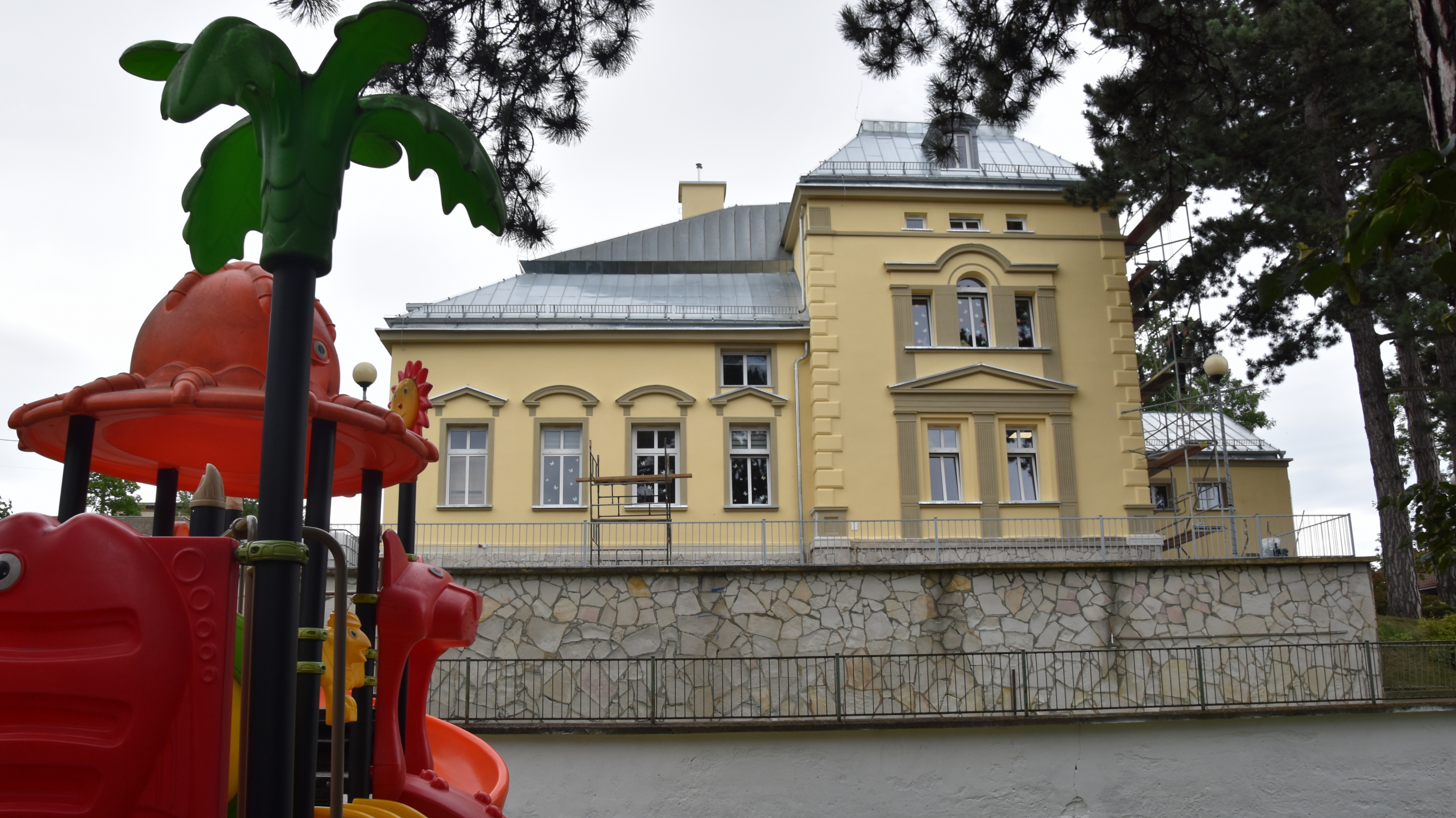 Kamienica z piaskową elewacją, przed nią mur