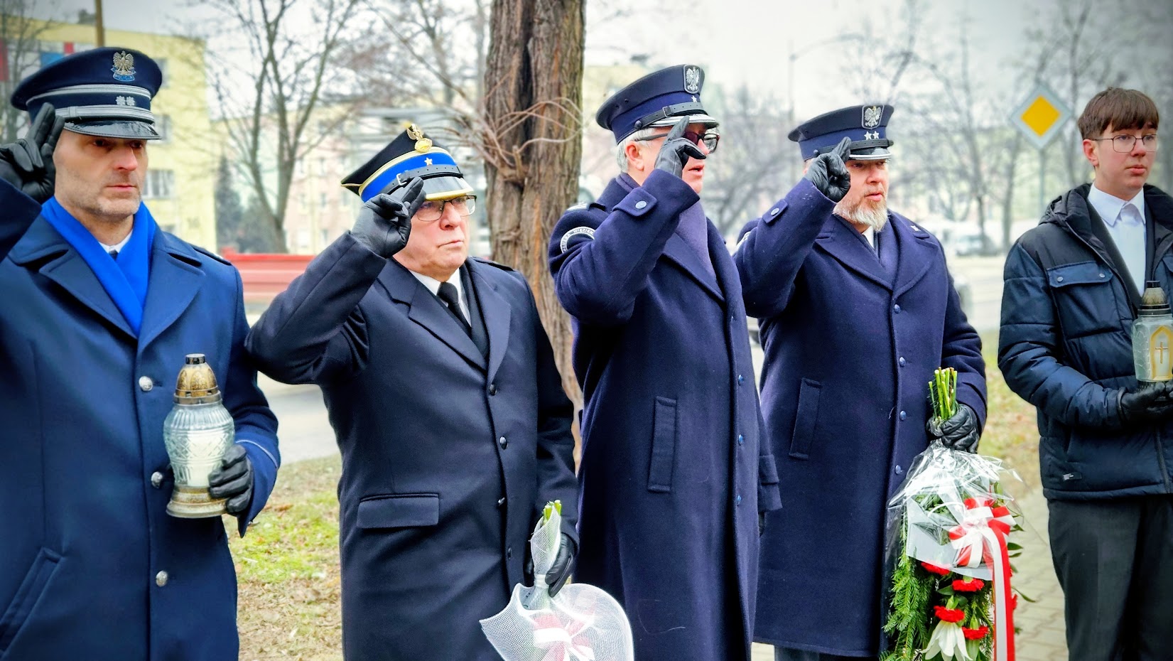 grupa mudurowych oddaje hołd salutując