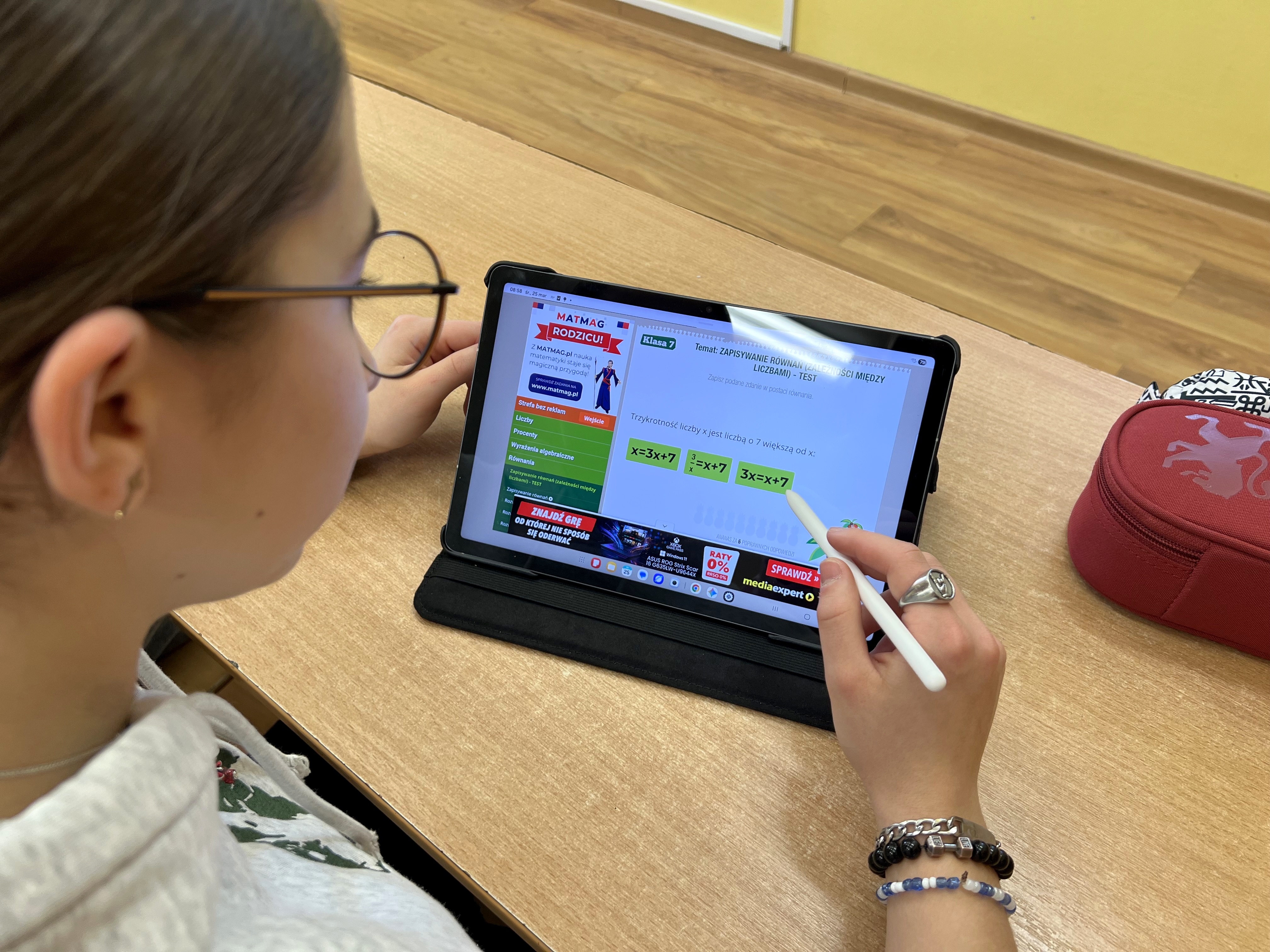Uczennica wykonująca test z matematyki na tablecie