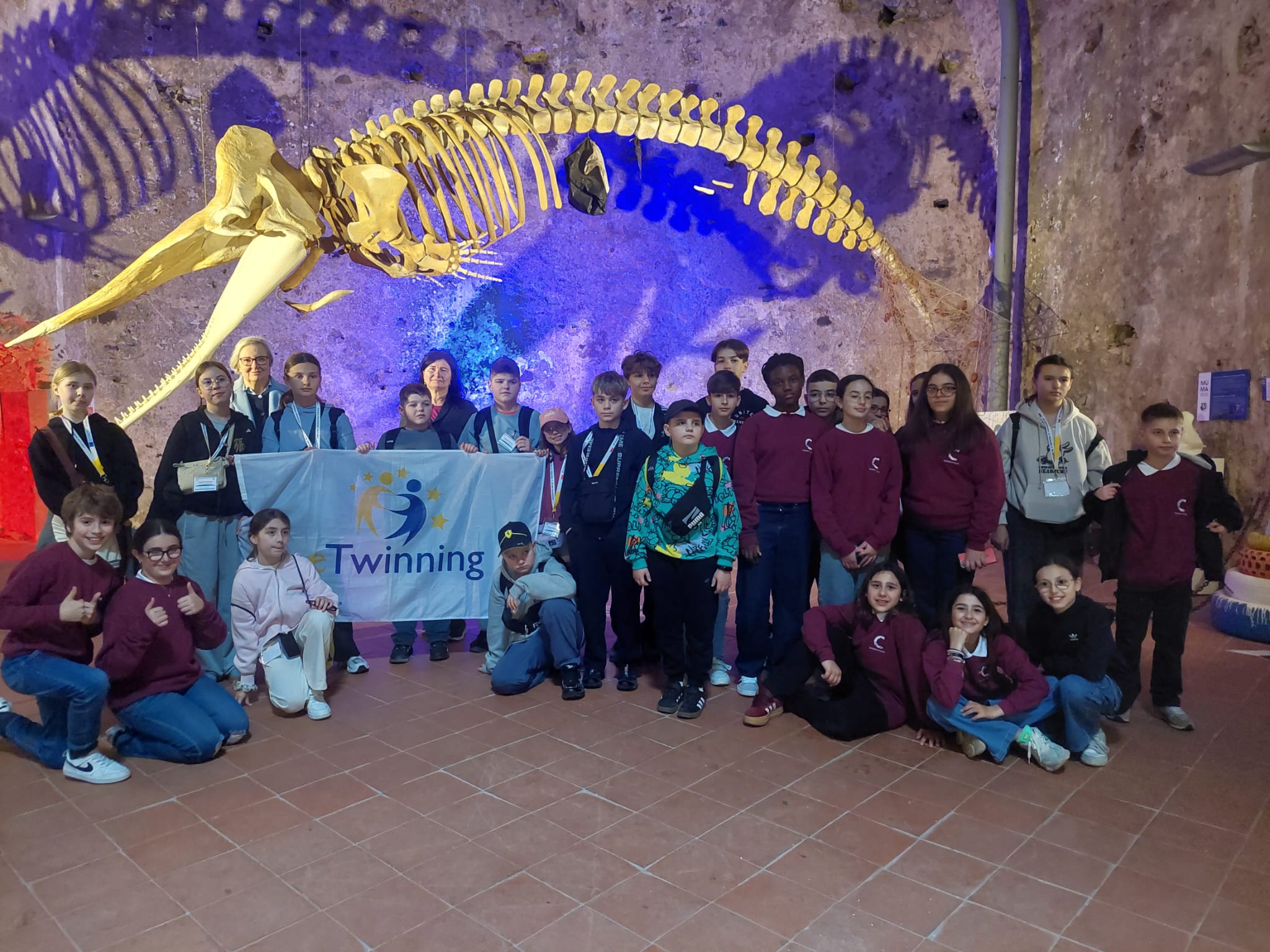 Grupa dzieci w muzeum, nad nimi szkielet wieloryba