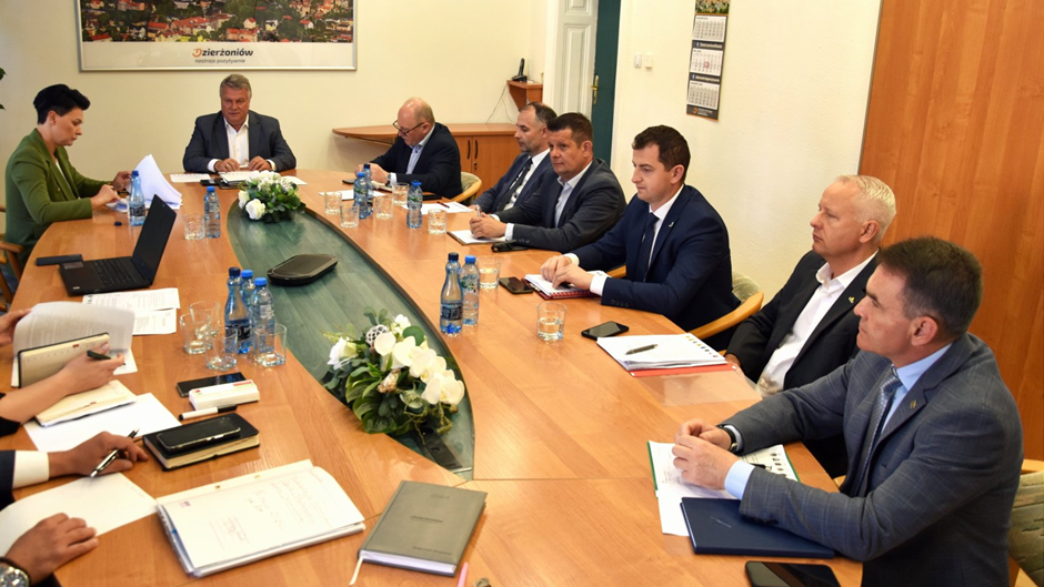 Osiem osób siedzących przy owalnym stole