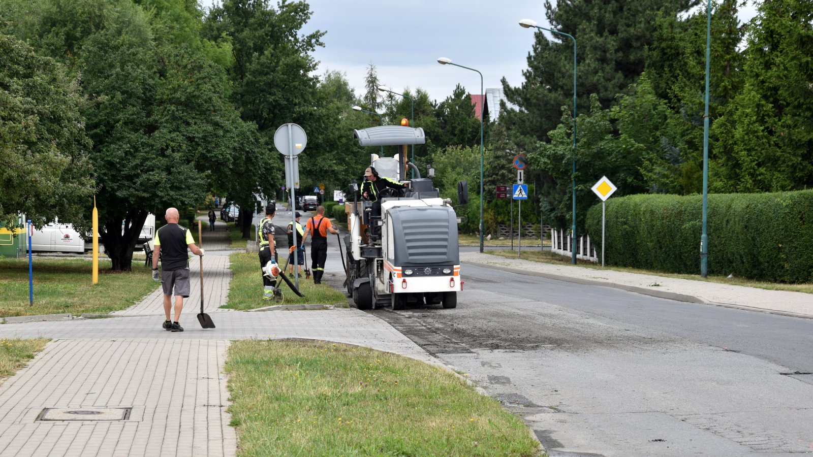 Remont osiedlowej drogi, na jeżdni maszyna do prac drogowych 