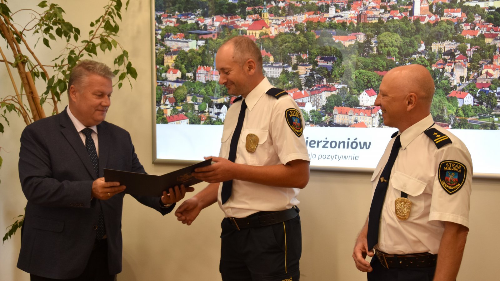 Strażnik miejski odbierający list od mężczyzny w garniturze 