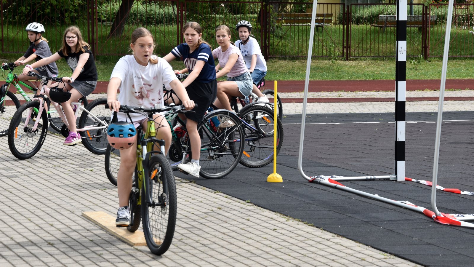 Dziewczyna jadąca na rowerze po boisku szkolnym