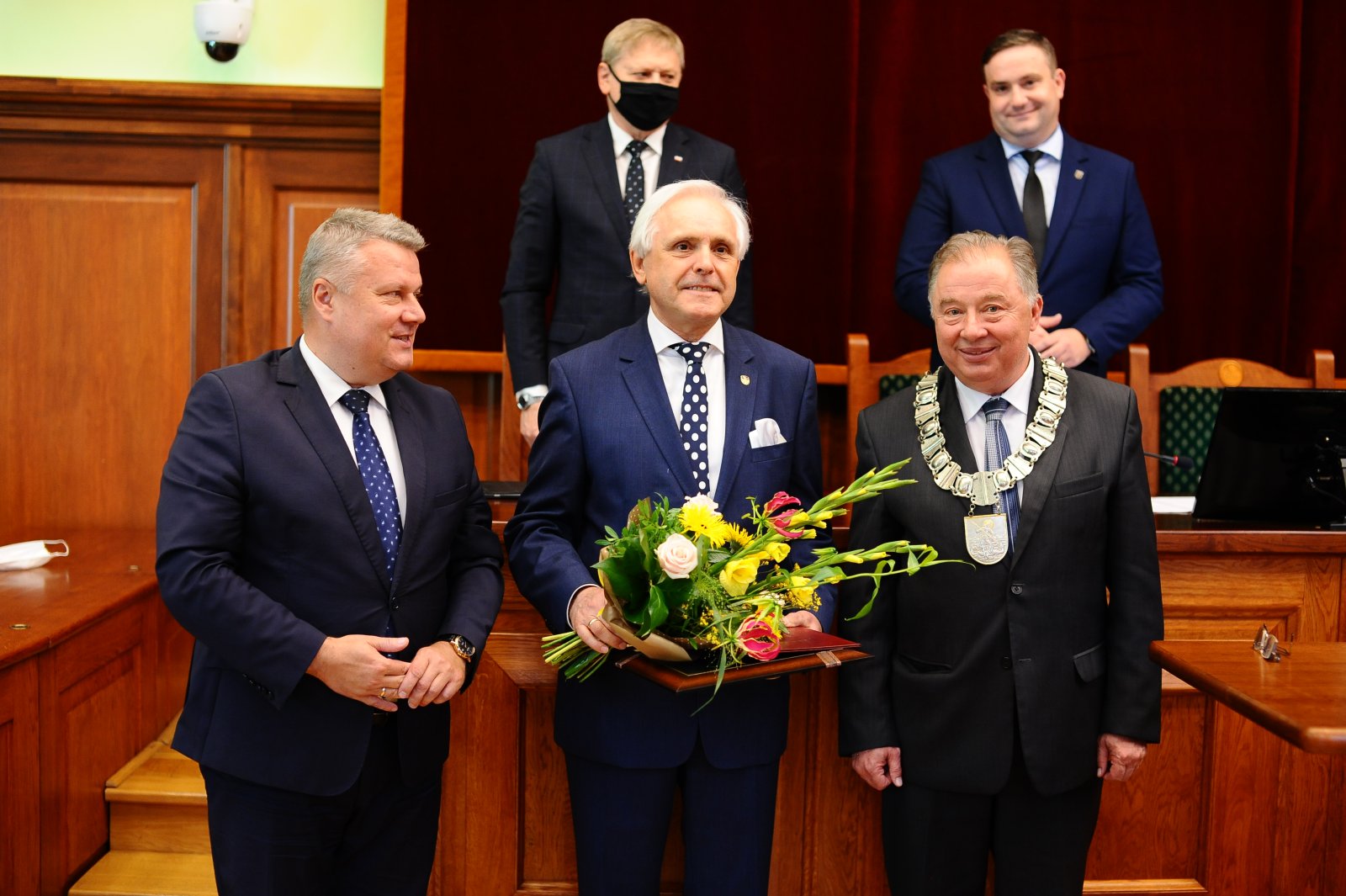 Marek Piorun z kwiatami i medale, po bokach burmistrz i przewodniczący rady, za nimi dwóch wiceprzewodniczących