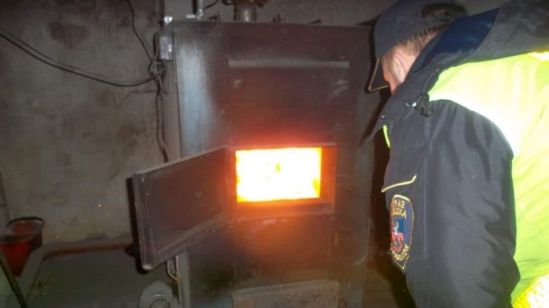 Strażnik miejski zaglądający do pieca