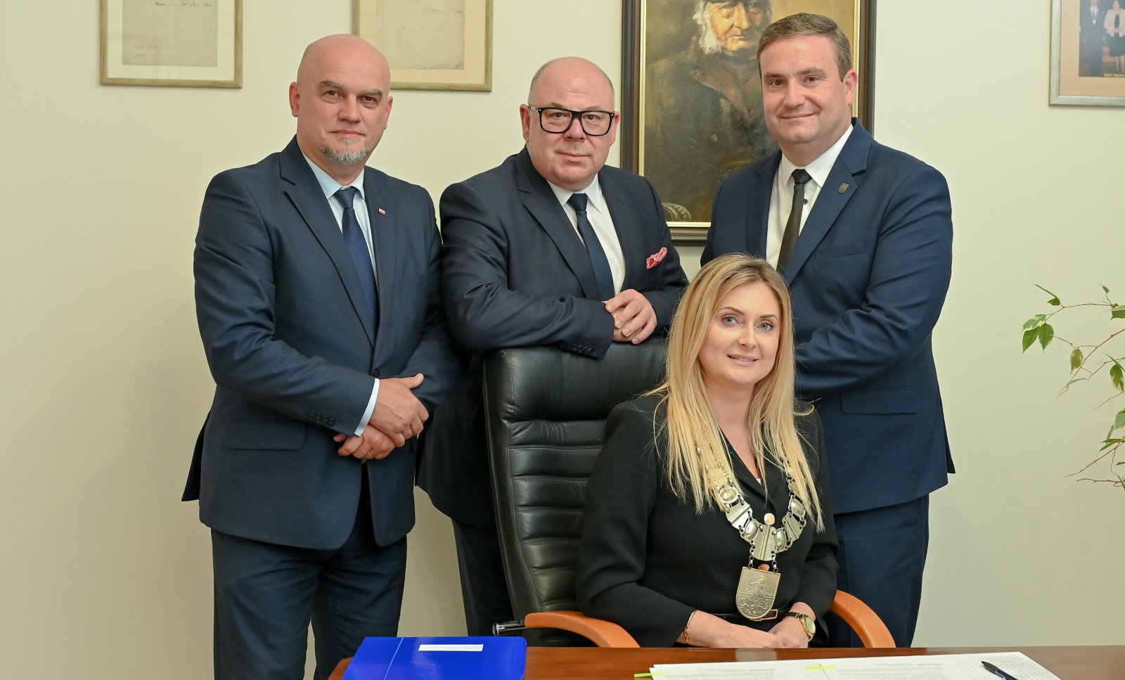 Przewodnicząca Rady Miejskiej siedząca przy stole, za nią trzech wiceprzewodniczących