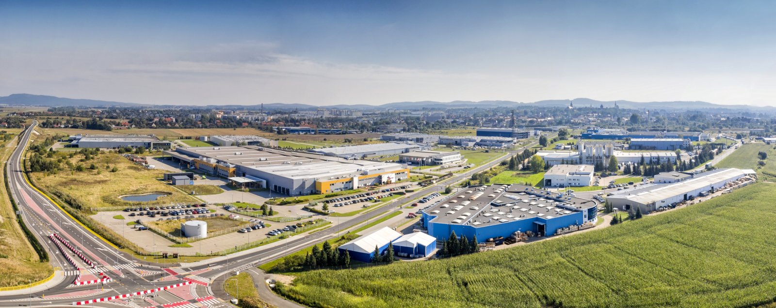 Zakłady przemysłowe z lotu ptaka, na drugim planie Dzierżóniów