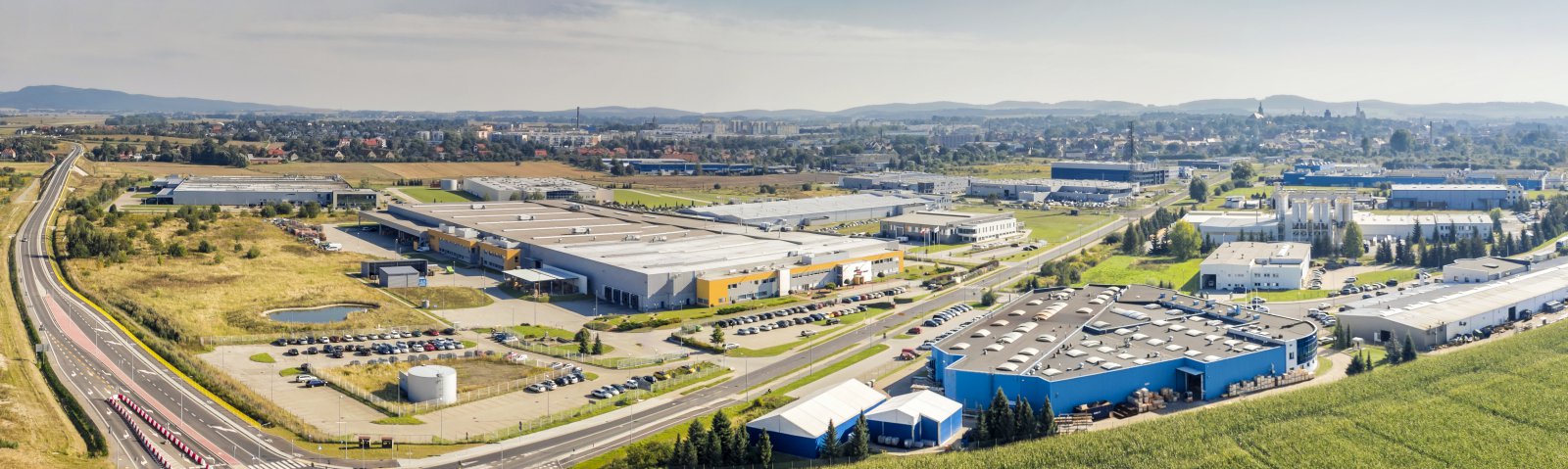 Zakłady przemysłowe z lotu ptaka, w drugim planie panorama miasta