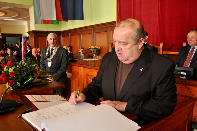 Andrzej Wojtal wpisujący się do księgi pamiątkowej