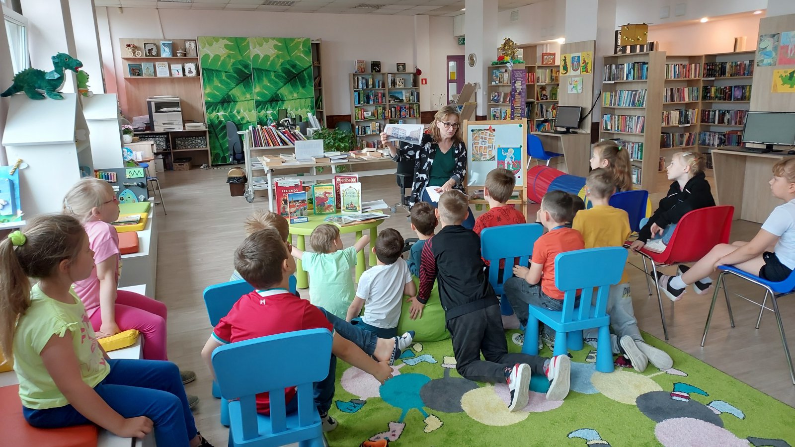 Biblioteka, dzieci siedzące na ziemi 