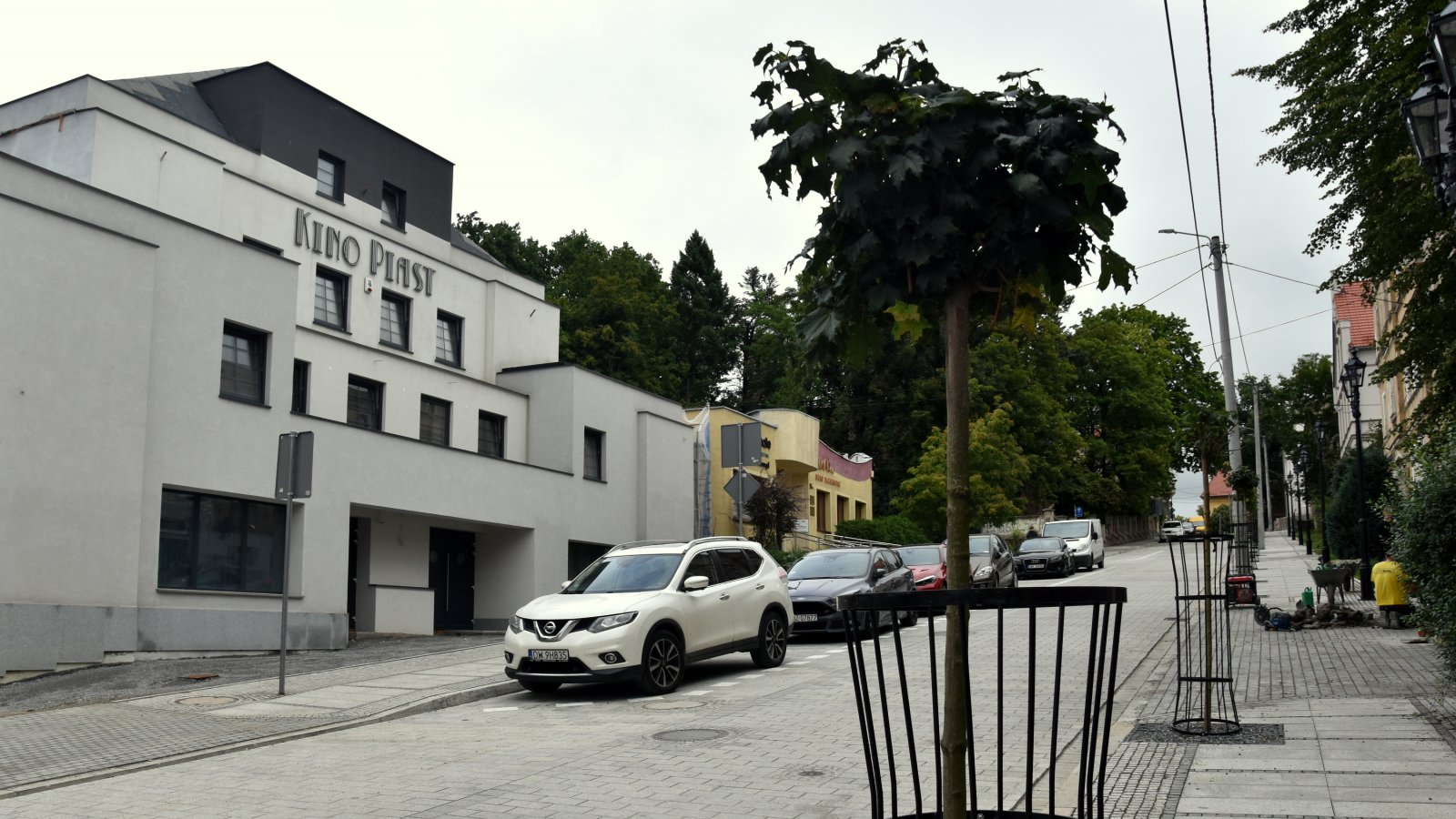Droga z kostki kamiennej i odnowiona kamienica z napisem Kino Piast