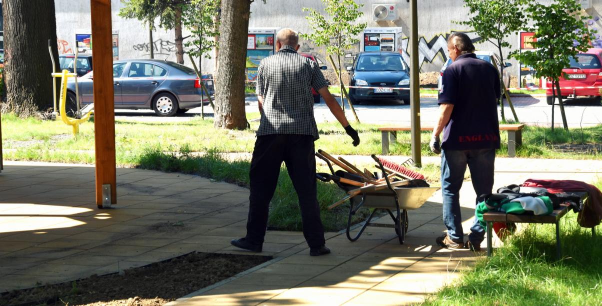 Dwóch bzerobotnych sprzątających teren Centrum Seniora w Dzierżoniowie