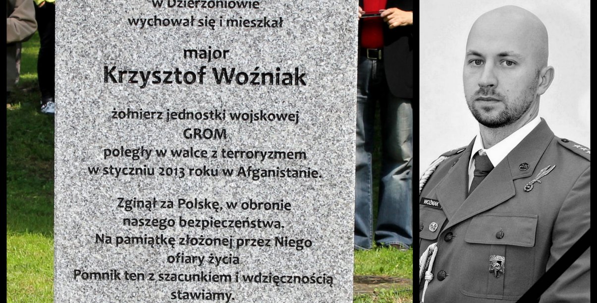 Kamienny obelisk, pod nim wiązanki kwiatów i zdjęcie śp. Krszytofa Woźniaka