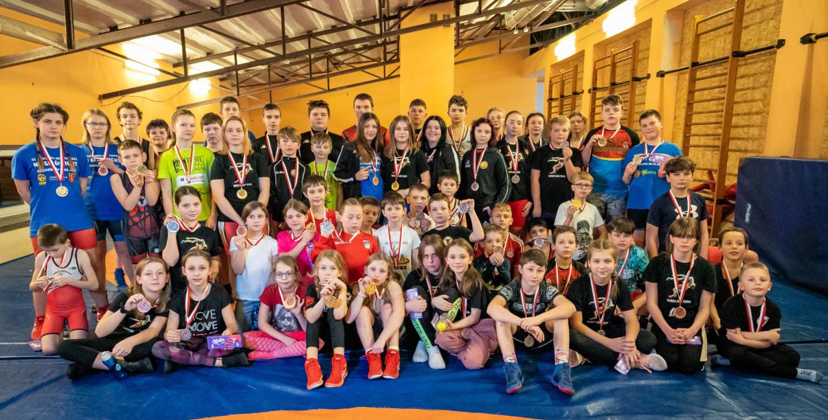 Grupowe zdjęcie zapaśników w hali spotowej