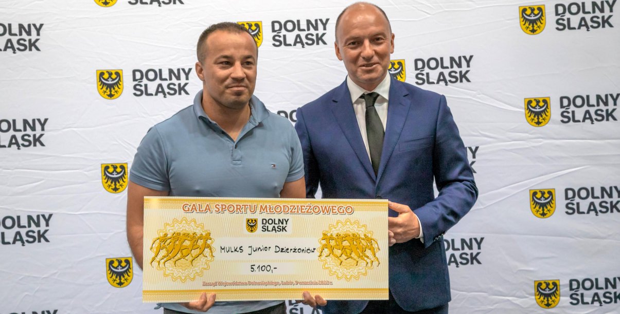 Dwóch meżczyzn trzmających symboliczny czek