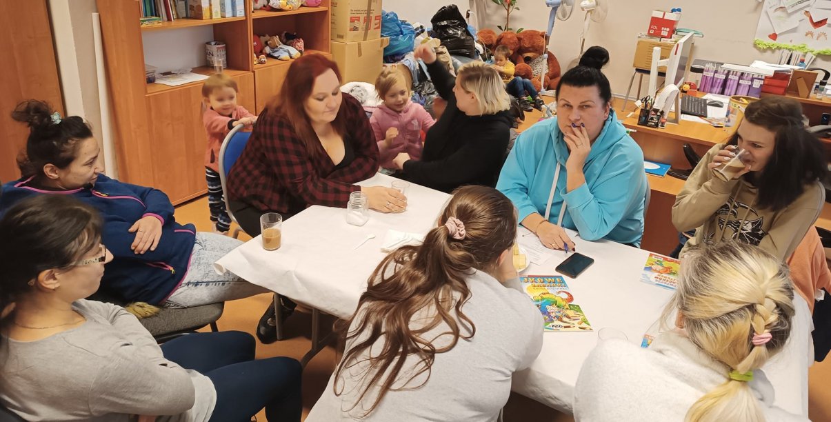 Grupa kobiet z dziećmi przy stole