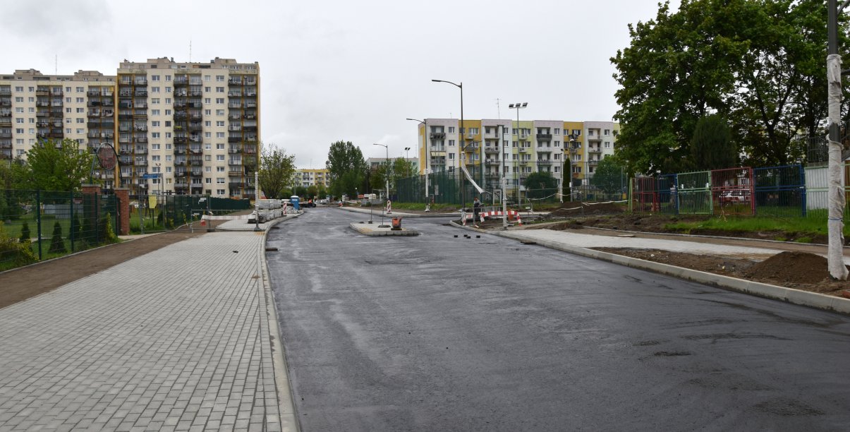 Droga w trakcie remontu, w tle wieżowce osiedlowe