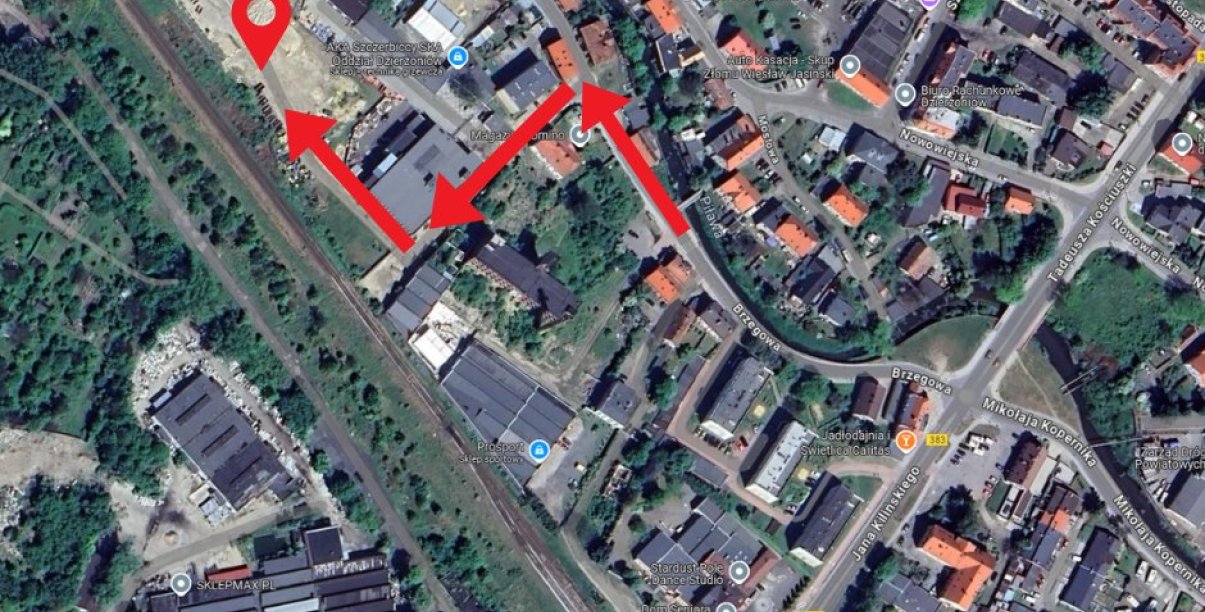 Fragment miasta widziany z góry, czerwonymi strzałkami zaznaczonao miejsce dojazdu do odbioru worków i piasku
