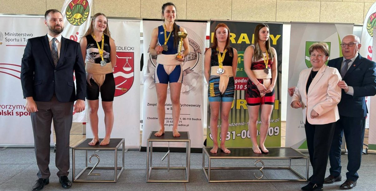 Cztery zawodniczki na podium z pucharami i dyplomami