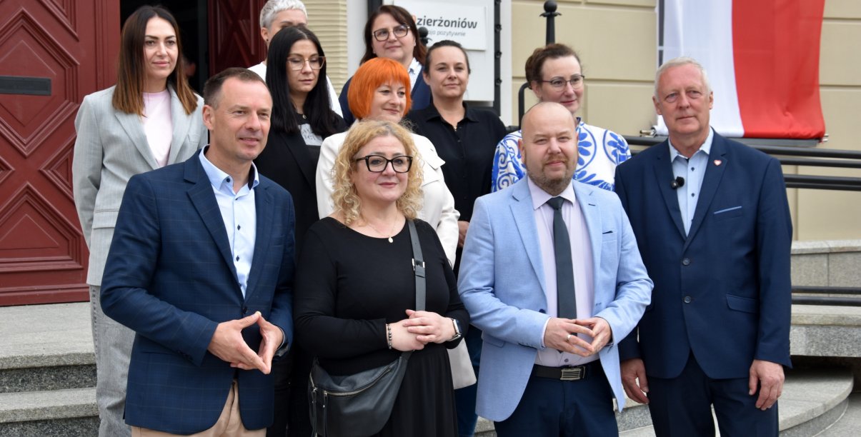 Grupa osób przed wejściem do ratusza na wspólnym zdjęciu