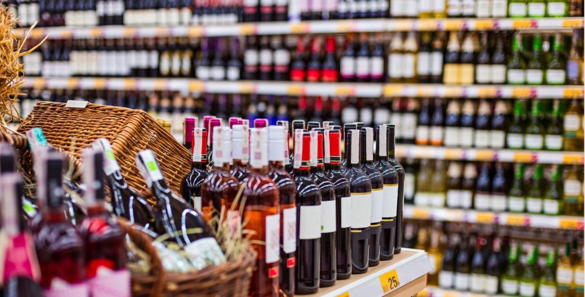 sklep z alkoholem, na półka stoją rzędy butelek w różnych kolorach