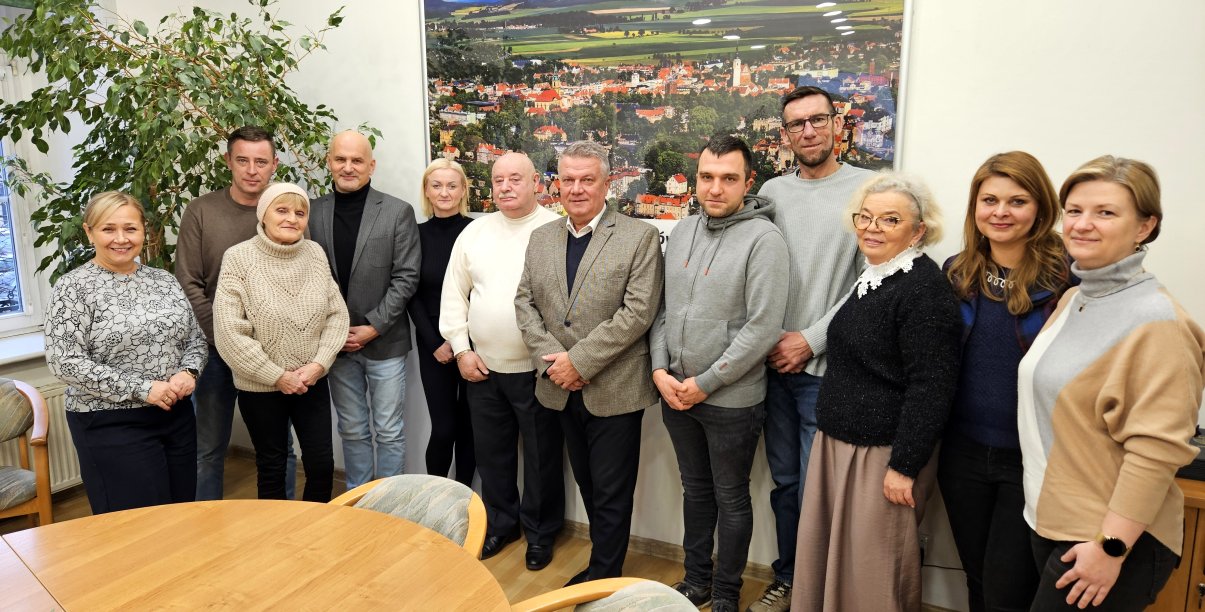 Grupa ludzi, przedstawicieli nagrodzonych wspólnot mieszkaniowych, z burmistrzem