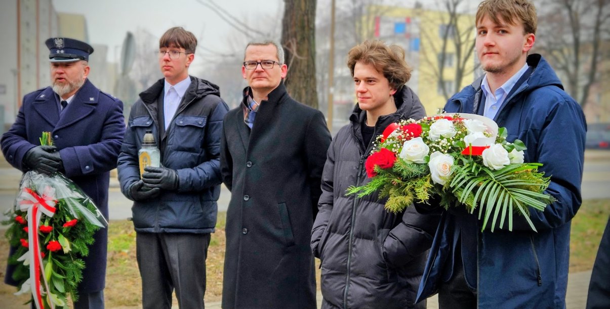 delegacje z wiązankami kwiatów biało-czerwonych