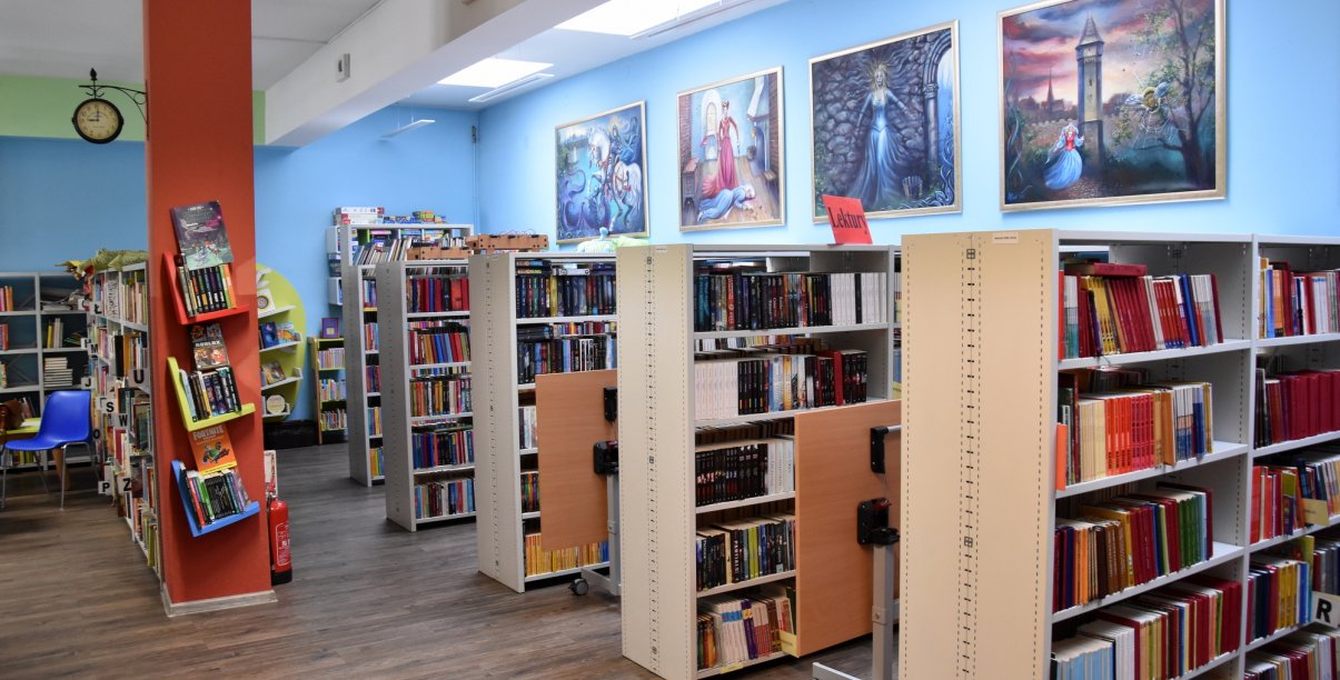 Wnętrze biblioteki, regały z książkami dla dzieci