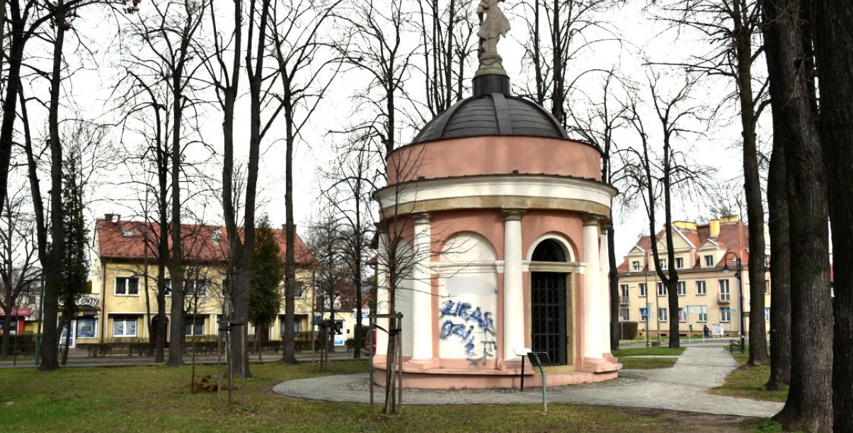 Niewielka, okrągła kaplica w parku, z rzeźbą kobiety wieńczącej kopułę