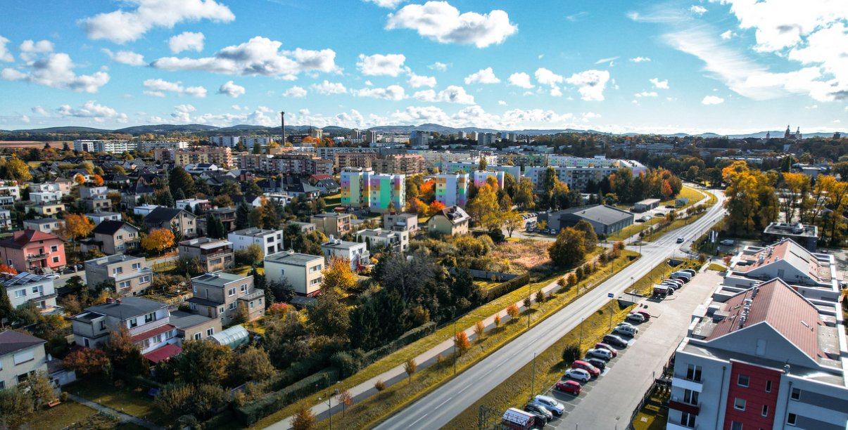 Dzierżoniów z lotu ptaka, za miastem góry i błękitne niebo