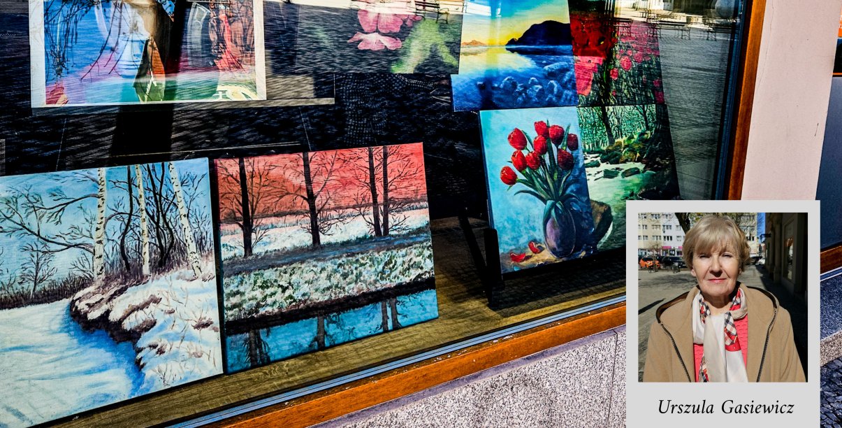 Witryna okienna z pracami malarskimi i zdjęciem autorki