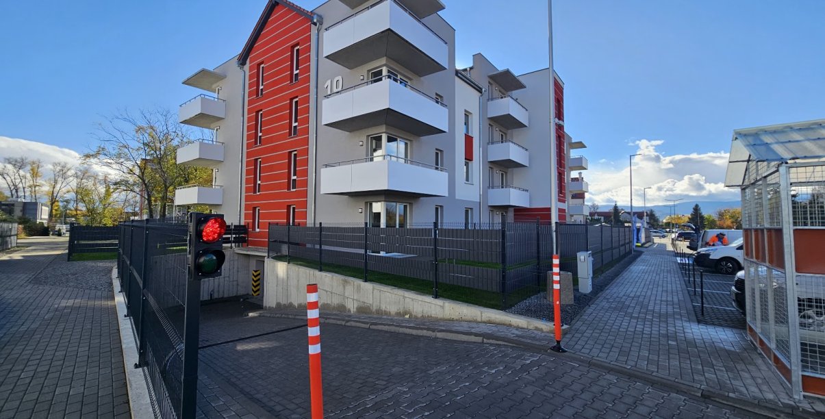 Czteropiętrowy udynek TBS-u, z dużymi balkonami i ogrodzeniem wokół