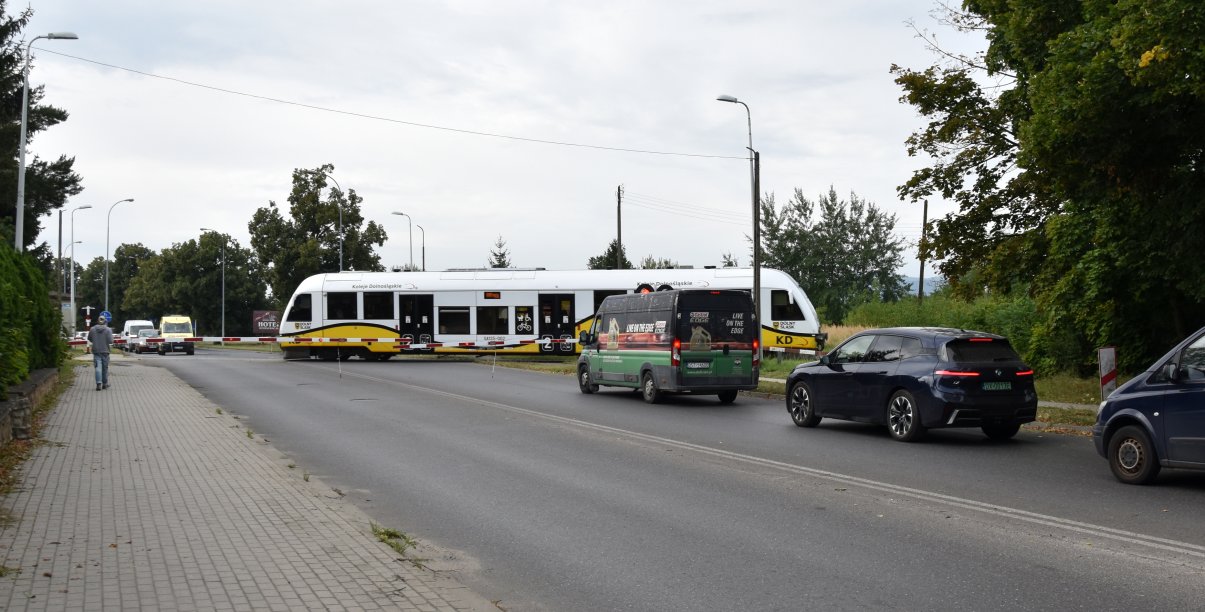 Szynobus przejeżdżający przez przejazd, przed przejazdem samochody 