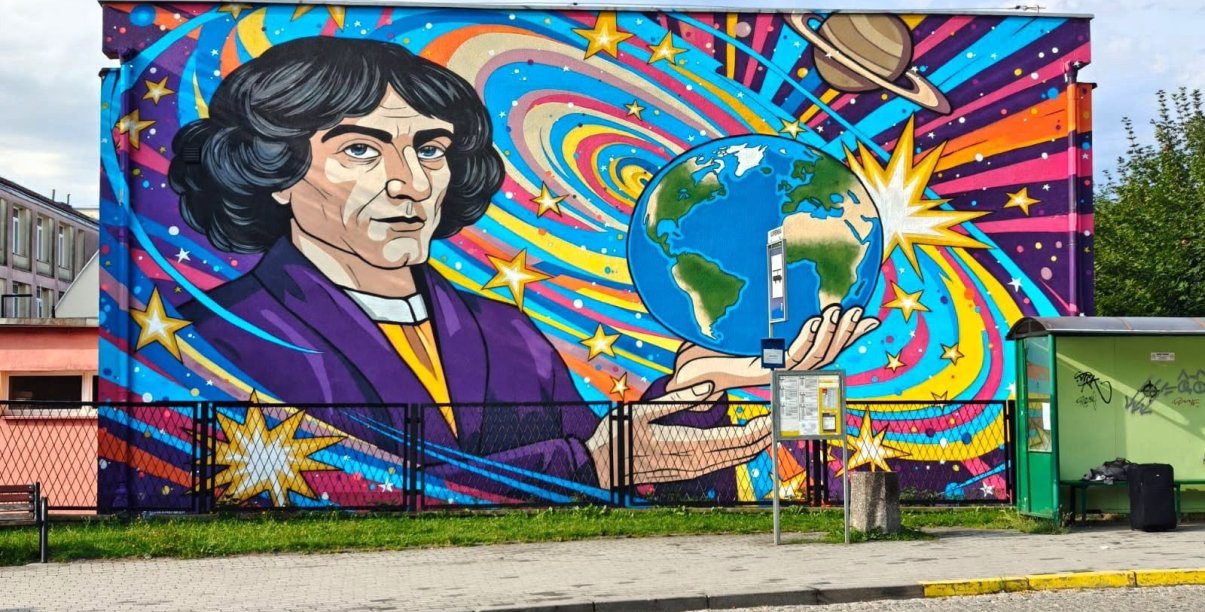 Kolorowy mural przedstawiający kopenika trzymającego na dłoni kulę ziemską