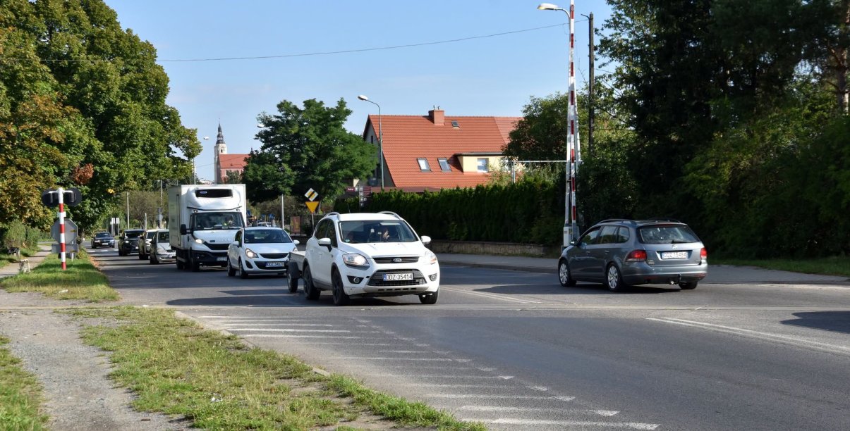 Auta jadące przez przejazd kolejowy