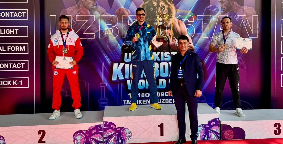 Maksymilian Palej w biało-czerwonym stroju reprezentacji Polski stoi na drugim miejscu podium. Za nim napis Uzbekistan