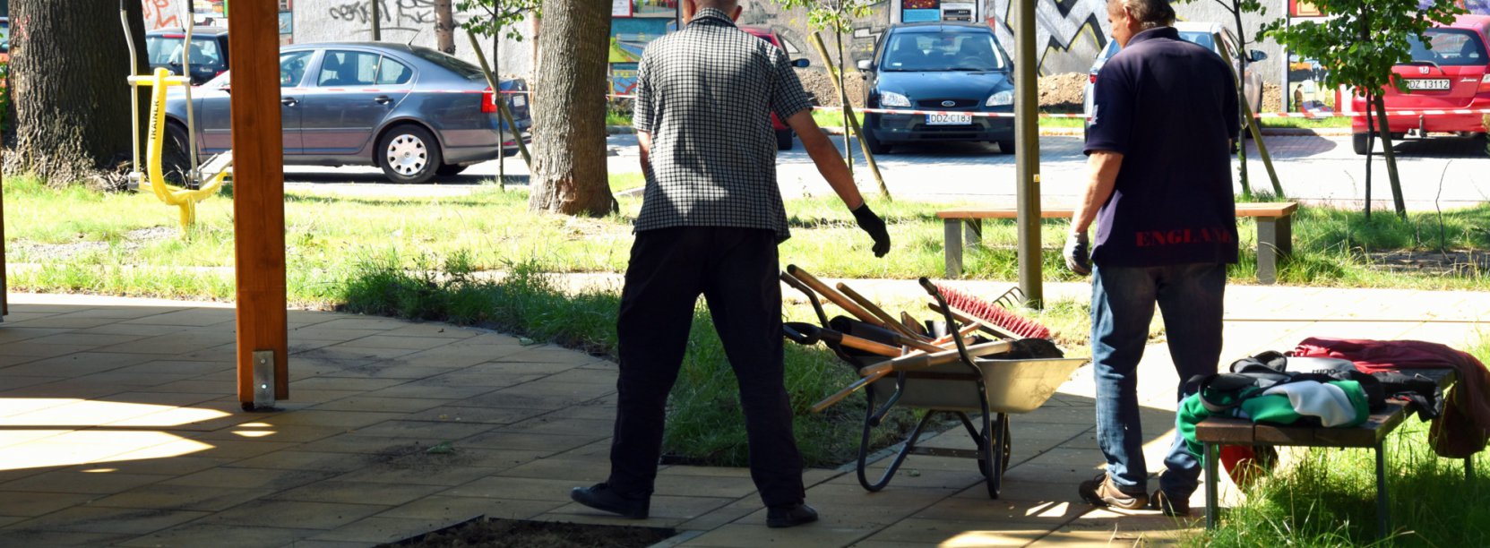 Dwóch bzerobotnych sprzątających teren Centrum Seniora w Dzierżoniowie