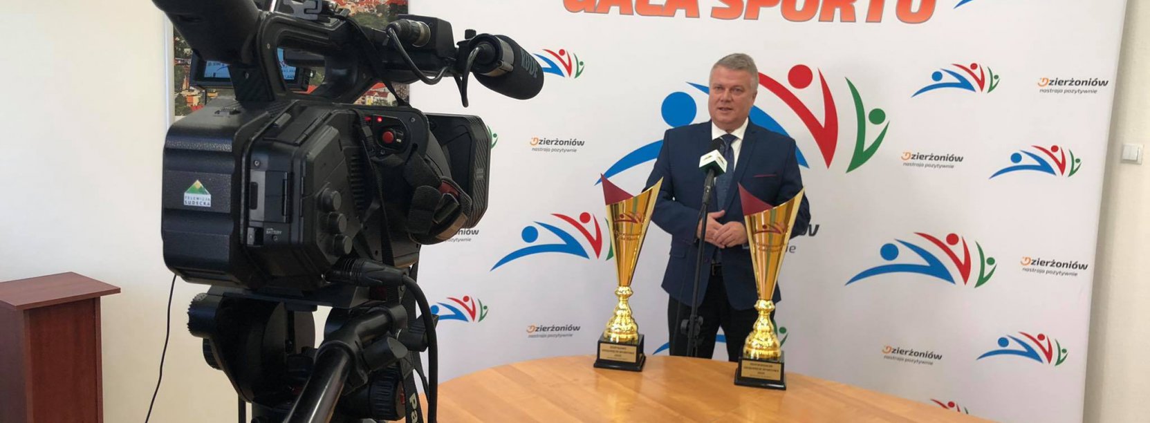 na pierwszym planie kamera TV Sudeckiej, w tle burmistrz Dzierżoniowa Dariusz Kucharski i puchary 6. Dzierżoniowskiej Gali Sportu