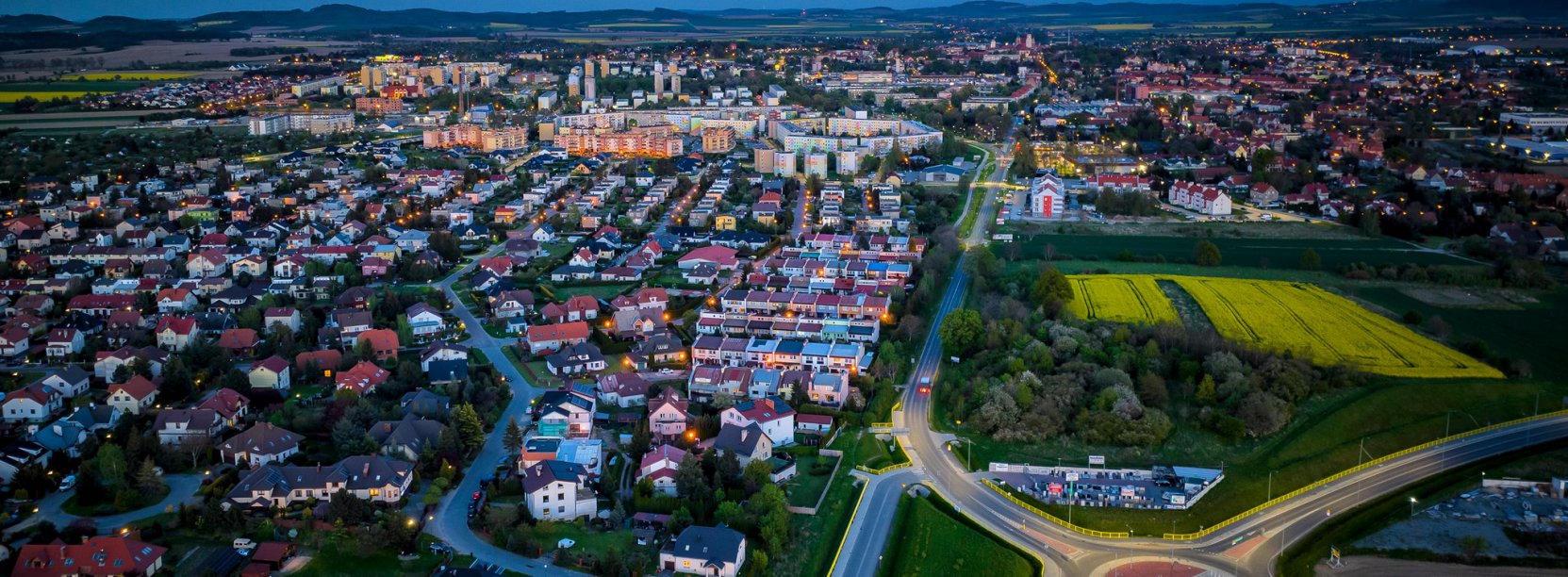 Miasto wieczorem widziane z góry, na pierwszym planie duże rondo