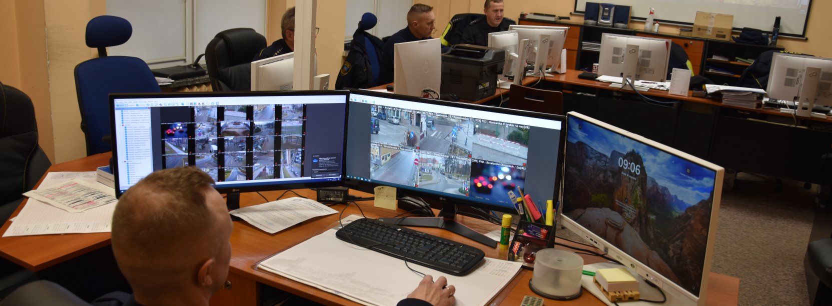 Straznik miejski obserwuje na ekranach monitoring miasta