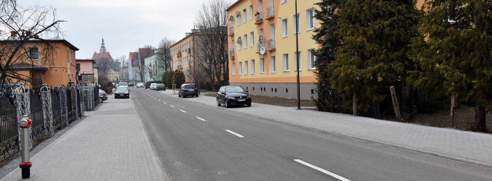 Ulica Słowiańska po remoncie, po bokach nowe chodniki, za nimi domy jedno i wielorodzinne