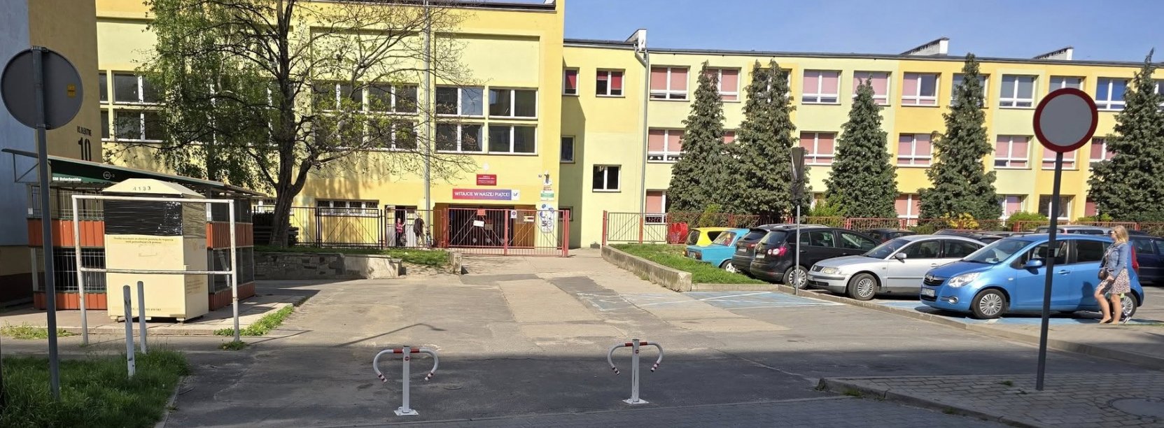 Wjazd do budynku szkoły podstawowej, w tle budynek sali gimnastycznej
