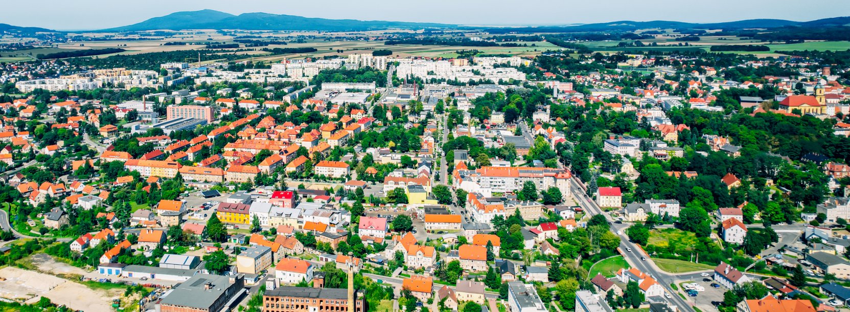 Dzierżoniów z lotu ptaka w słoneczny dzień, w tle góry