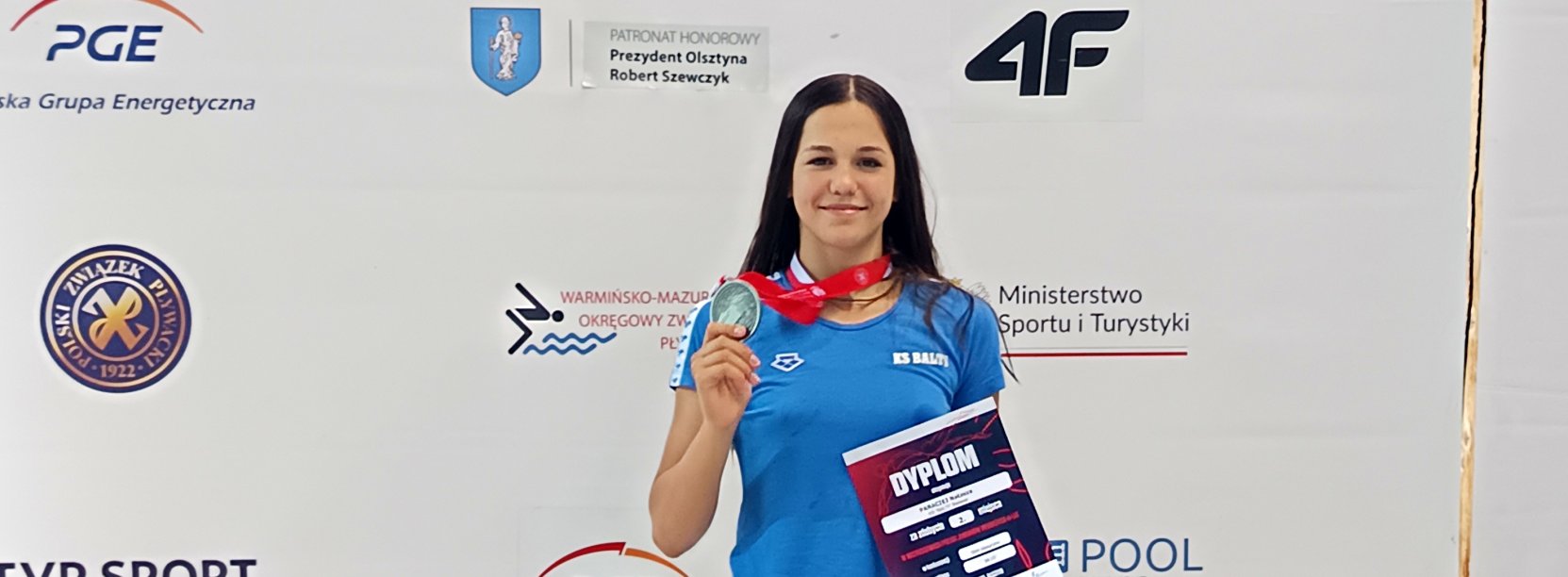 Uśmiechnięta Natasza Paraciej ze srebrnym medalem i dyplomem w dłoniach